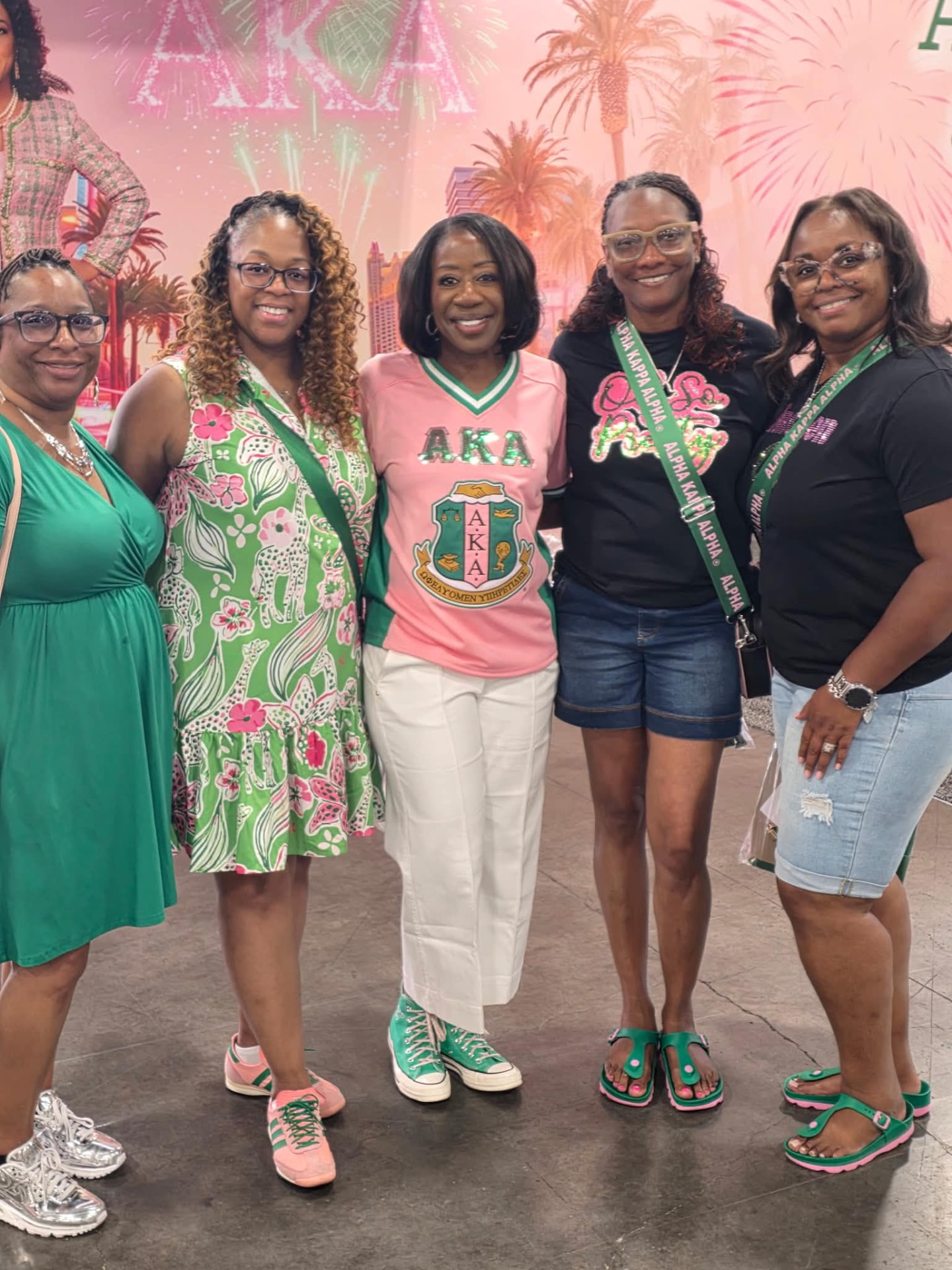 Five sorors posing together in pink and green attire