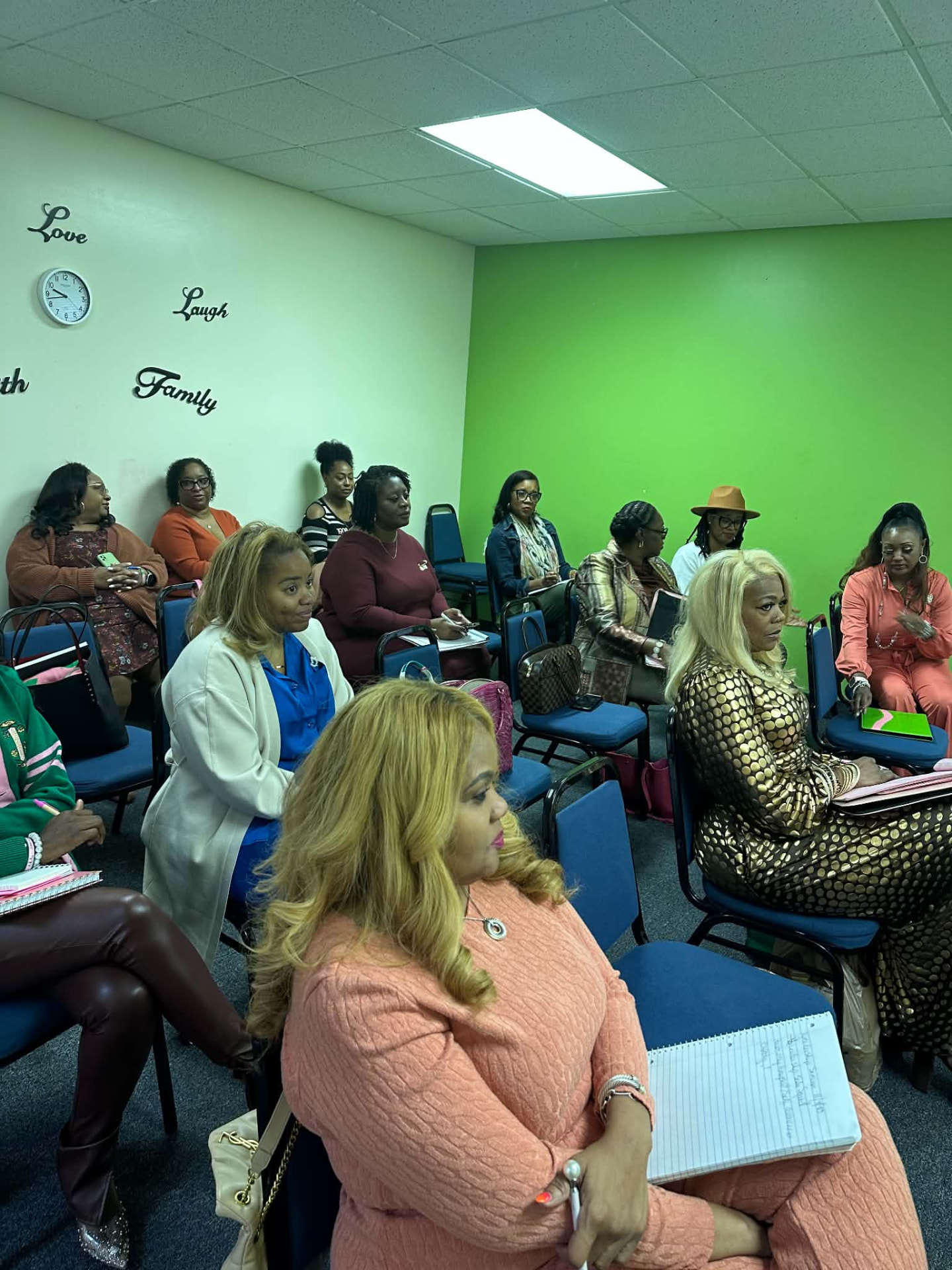 Women seated with notebooks during a group meeting