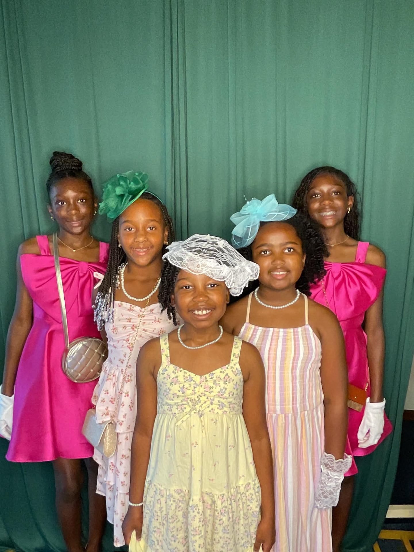 Young ladies dressed up in pink and pastels with hats and gloves