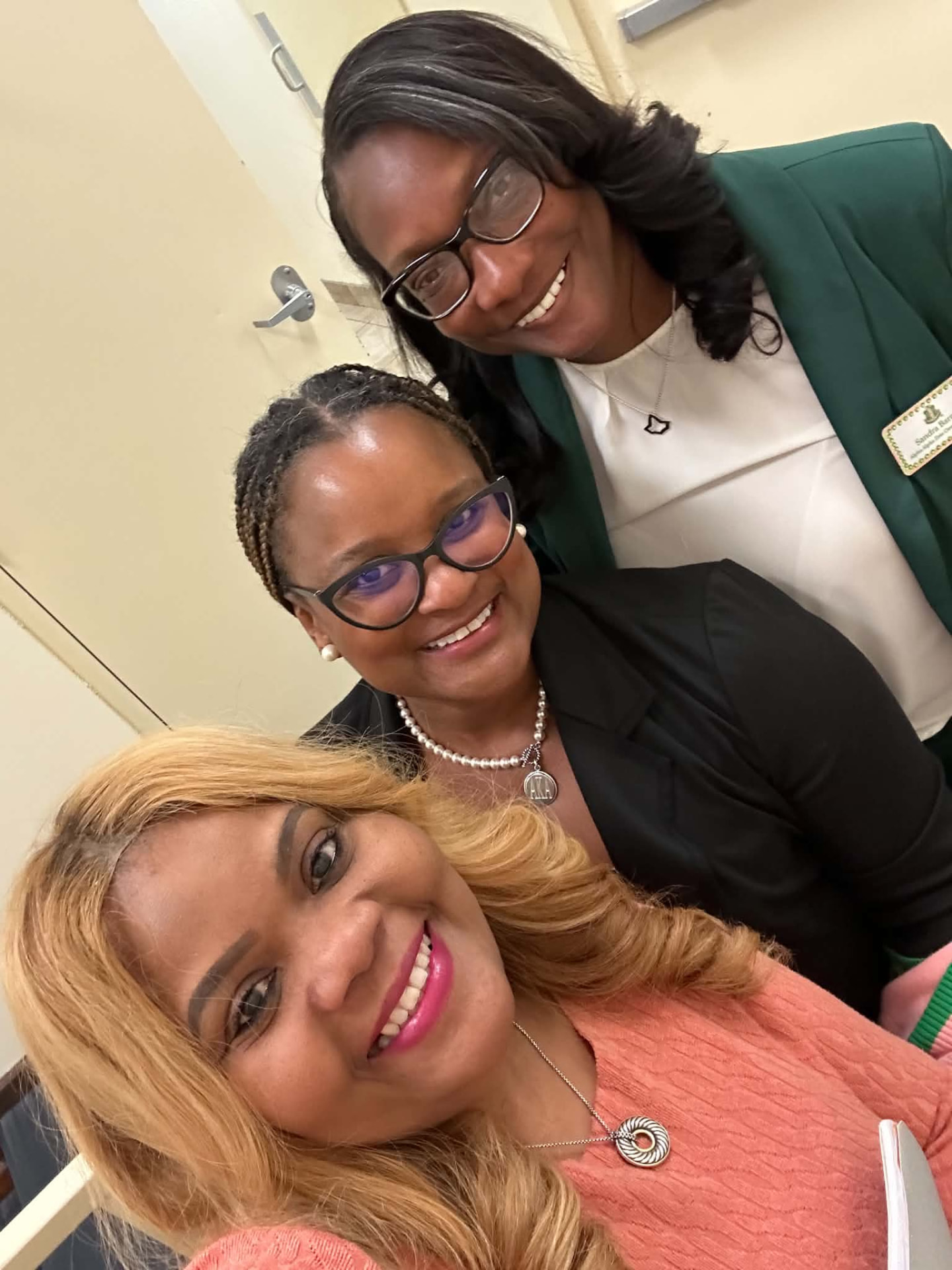 Three women smiling together for a photograph